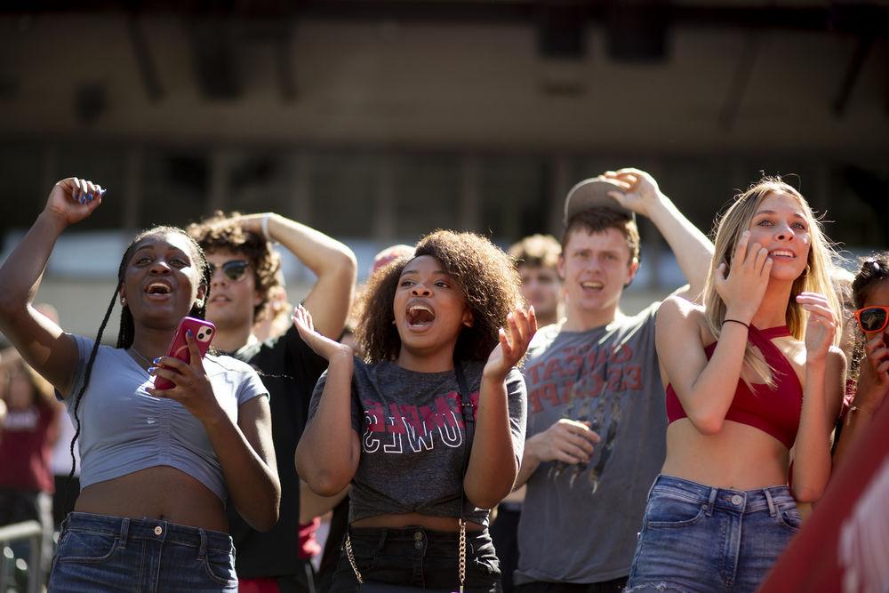 Four Temple students cheering on the Temple Owls football team at 首页coming